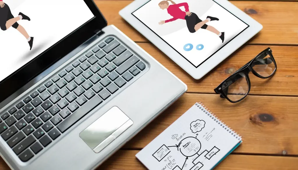 Effektiv abnehmen mit App – Dein Weg zur Fitness! 1 Laptop und Tablet mit Fitness-Apps neben einem Notizblock für Trainingspläne